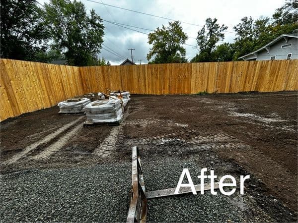 Landscape renovation with cleared ground and wooden fence after construction.